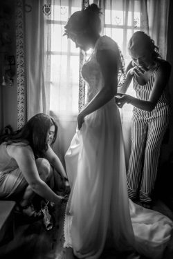 Bride putting on wedding dress